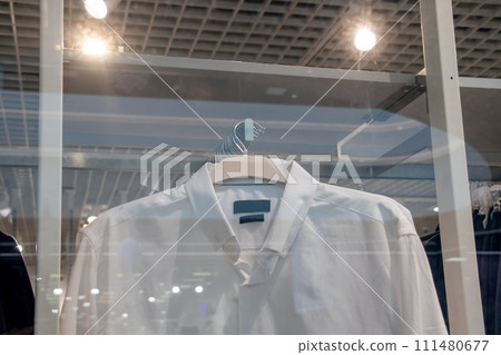 White shirts on hangers in store closeup White shirts on hangers in store closeup 111480677