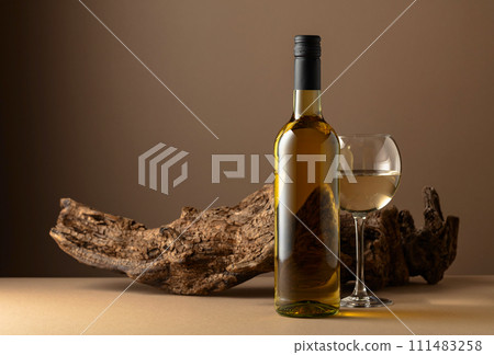White wine and old snag on a beige background. White wine and old snag on a beige background. 111483258