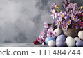 A tranquil Easter composition with pastel eggs and delicate purple flowers against a soft grey backdrop. Easter greeting card, Banner with copy space 111484744
