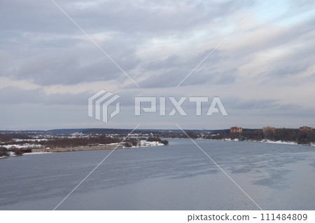 river on a sunny evening. Trees and shrubs. Landscape of winter nature, river banks overgrown with bushes. 111484809