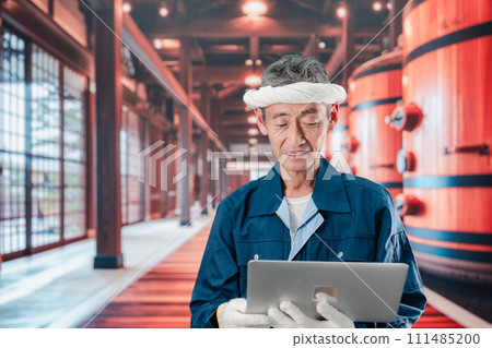 An elderly man working at a sake brewery 111485200