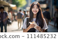 Asian girl eating while walking 111485232
