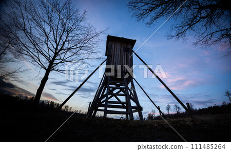Wooden hunting tower silhouette with night sky on background Wooden hunting tower silhouette with night sky on background 111485264