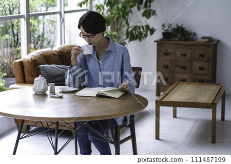中年婦女在客廳喝茶看書 111487199
