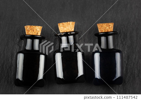 apothecary black glass bottles on black 111487542
