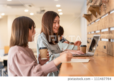 Business women having a meeting while using a computer in an office/cafe 111487764