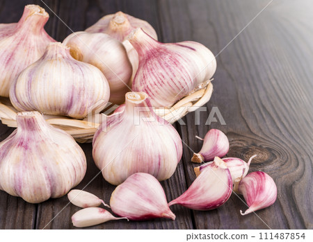Cloves of garlic on wooden background, concept healthy lifestyle. Cloves of garlic on wooden background, concept healthy lifestyle. 111487854