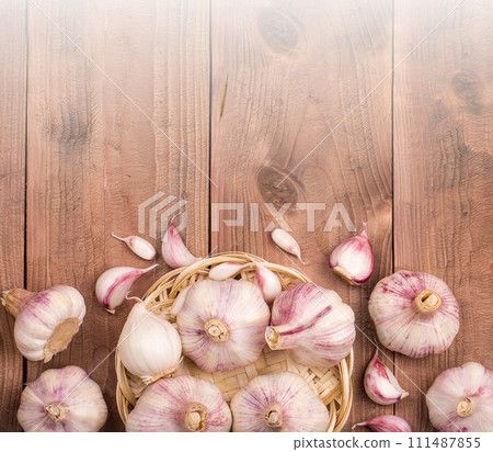Cloves of garlic on wooden background, concept healthy lifestyle. Cloves of garlic on wooden background, concept healthy lifestyle. 111487855
