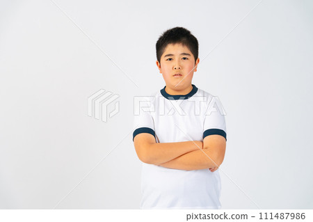 一個穿著運動服、雙臂交叉的男孩 一個穿著運動服、雙臂交叉的男孩 111487986