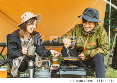 秋季和冬季,男女露營者在露營地製作露營食品 秋季和冬季,男女露營者在露營地製作露營食品 111488218
