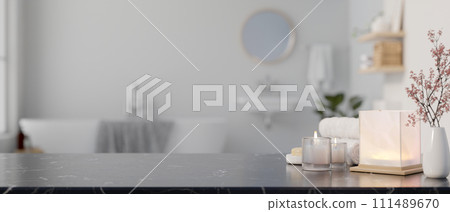 A copy space on a black marble countertop with toiletries in a modern white and clean bathroom. 111489670