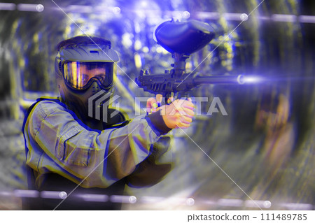 Paintball player recklessly aims with a gun on battlefield 111489785
