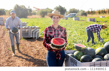 Happy woman farmer with half a watermelon in her hands posing in farmer field 111490911