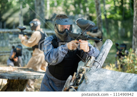 Man eliminating opponents on paintball field 111490942