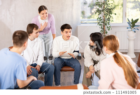 Positive guy team leader holding meeting with group of students 111491005
