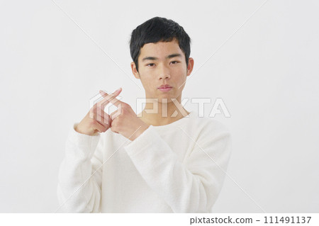 A boy making a cross-mark gesture with his finger, white background A boy making a cross-mark gesture with his finger, white background 111491137