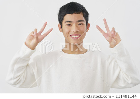 A boy making a peace sign with both hands, white background A boy making a peace sign with both hands, white background 111491144