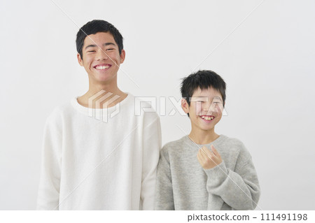 微笑的十幾歲兄弟的肖像，白色背景，看著相機 111491198