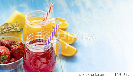 Fresh pineapple and strawberry smoothie in glasses with fruits on a blue wooden rustic background Fresh pineapple and strawberry smoothie in glasses with fruits on a blue wooden rustic background 111491232