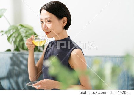A woman in her 30s drinking herbal tea A woman in her 30s drinking herbal tea 111492063