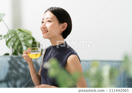 A woman in her 30s drinking herbal tea A woman in her 30s drinking herbal tea 111492065