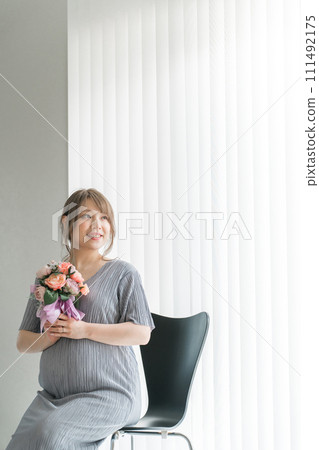 Bouquet of flowers, pregnant woman with bouquet, maternity photo (sitting on a chair) 111492175