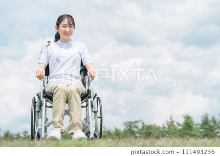 A smiling Japanese woman sitting in a wheelchair (blue sky) A smiling Japanese woman sitting in a wheelchair (blue sky) 111493236