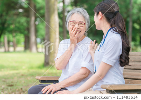 老人在公園裡聊天，一位微笑的護理人員女士（說話/有趣） 111493614
