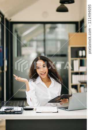 Confident business expert attractive smiling young woman holding digital tablet  . 111494095