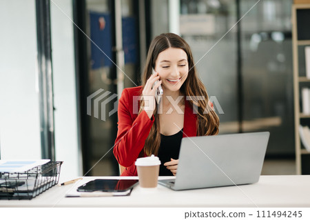 Confident Asian woman with a smile standing holding notepad and tablet 111494245