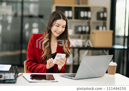 Confident woman with a smile standing holding notepad and tablet 111494250
