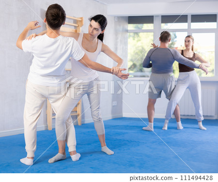 Young girl applying throwing technique on her opponent in sports hall 111494428