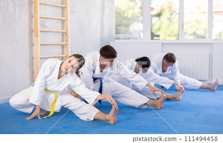 Group of people doing stretching in studio Group of people doing stretching in studio 111494458