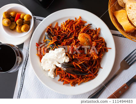 Fideua, noodle paella on white plate 111494483