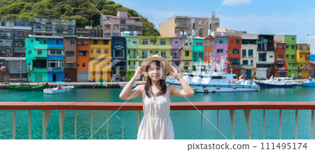 woman traveler visiting in Taiwan, Tourist with hat sightseeing in Keelung, Colorful Zhengbin Fishing Port, landmark and popular attractions near Taipei city . Asia Travel concept 111495174