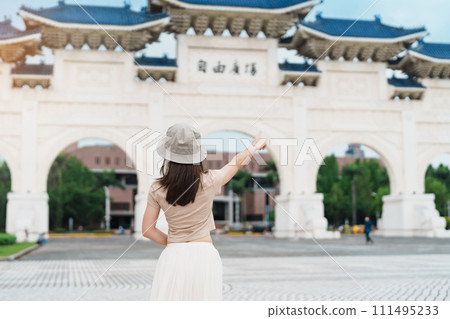 woman traveler visiting in Taiwan, Tourist with hat sightseeing in National Chiang Kai shek Memorial or Hall Freedom Square, Taipei City. landmark and popular attractions. Asia Travel concept 111495233