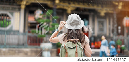woman traveler visiting in Taiwan, Tourist with hat sightseeing in Longshan Temple, Chinese folk religious temple in Wanhua District, Taipei City. landmark and popular. Travel and Vacation concept 111495237