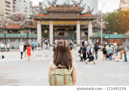 woman traveler visiting in Taiwan, Tourist with hat sightseeing in Longshan Temple, Chinese folk religious temple in Wanhua District, Taipei City. landmark and popular. Travel and Vacation concept 111495239
