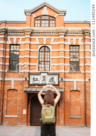 woman traveler visiting in Taiwan, Tourist sightseeing at Red House or old theater in Ximen, Taipei City. landmark and popular attractions. the chinese words mean red house in ximen 111495244