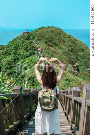 woman traveler visiting in Taiwan, Tourist with backpack sightseeing in Bitou Cape Hiking Trail, New Taipei City. landmark and popular attractions near Taipei. Asia Travel concept 111495600