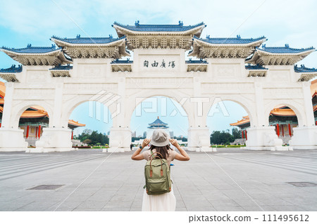 woman traveler visiting in Taiwan, Tourist with backpack sightseeing in National Chiang Kai shek Memorial or Hall Freedom Square, Taipei City. landmark and popular attractions. Asia Travel concept 111495612