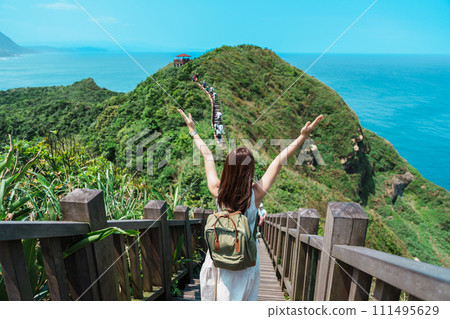woman traveler visiting in Taiwan, Tourist with backpack sightseeing in Bitou Cape Hiking Trail, New Taipei City. landmark and popular attractions near Taipei. Asia Travel concept 111495629