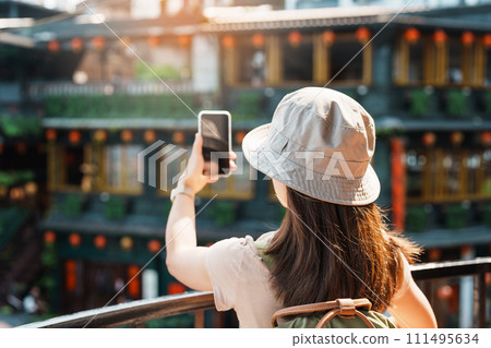 woman traveler visiting in Taiwan, Tourist taking photo and sightseeing in Jiufen Old Street village with Tea House background. landmark and popular attractions near Taipei city. Travel concept woman traveler visiting in Taiwan, Tourist taking photo and sightseeing in Jiufen Old Street village with Tea House background. landmark and popular attractions near Taipei city. Travel concept 111495634