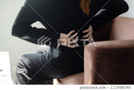 Asian female accountant is tired from working in a chair, stretching to relax and relax while working hard at the office 111496540