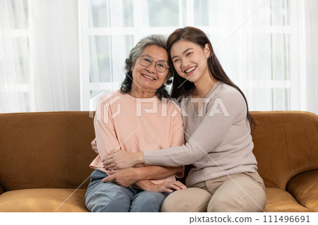 Heartfelt moment as a mid-age woman embraces her elderly mother with a warm and loving hug, celebrating the enduring bond between generations. Family Love Concept Heartfelt moment as a mid-age woman embraces her elderly mother with a warm and loving hug, celebrating the enduring bond between generations. Family Love Concept 111496691