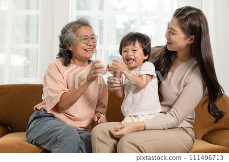 Happiness of Asian baby infant grandmother and mother enjoy drinking milk together at warmth place. Heartwarming scene of intergenerational joy share a delightful moment. Family Concept Happiness of Asian baby infant grandmother and mother enjoy drinking milk together at warmth place. Heartwarming scene of intergenerational joy share a delightful moment. Family Concept 111496713