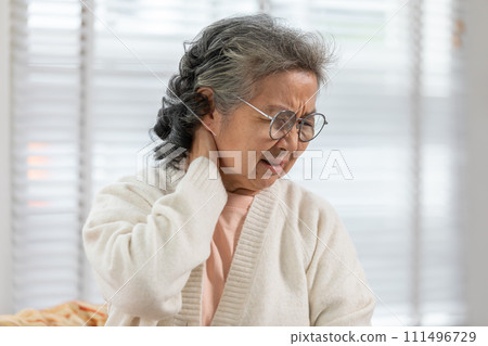 Asian Elderly senior woman with white hairs neck and shoulder pain and illness on sofa alone at home,Elderly Care and insurance Concept 111496729
