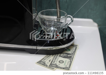 coffee machine, glass cup of coffee, banknotes lie nearby, coffee fee, financial forecast concept. 111498135