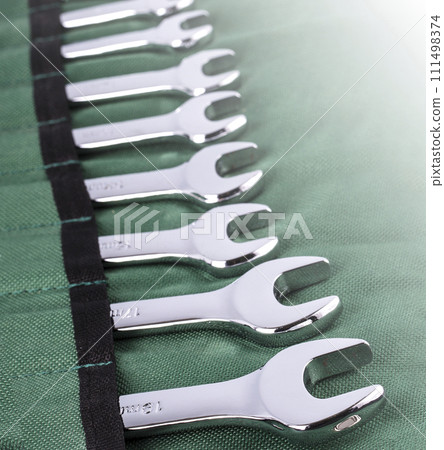 Open end wrench set on green cover on sunlight. Close up Open end wrench set on green cover on sunlight. Close up 111498374