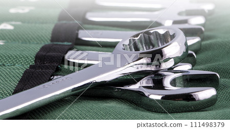 Open end wrench set on green cover on sunlight. Close-up 111498379